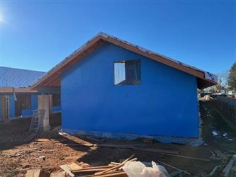 a building showing a gable end and wall board covering wood framing