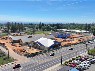 a high drone shot pointing South West showing many dirt paths across the property and the 4 buildings under construction