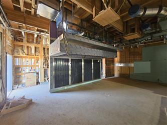 an interior of the kitchen with exposed wood framing and a newly installed vent