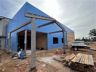 the front of Building A and office area ready for siding and window glazing with structural steel for covered doorway