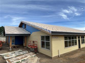 the two gable ends of Building B with partial siding and ready for roofing