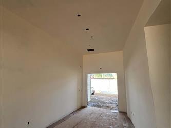 an interior hallway with finished drywall and unfinished plywood flooring