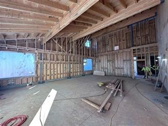 a framed classroom with concrete floor and wood trusses and beams