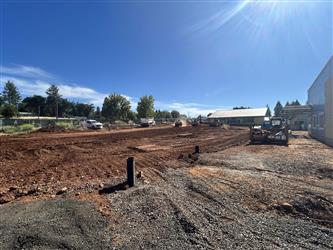A view of the front parking area, currently dirt with tractor tracks throughout