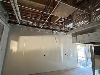 the interior wall of the kitchen in the multipurpose room with portions of the hood visible on the right