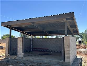 a large CMU block enclosure with an open awning on top for trash bin storage