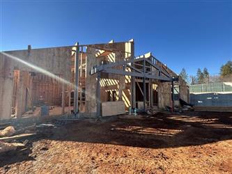 a large wood framed building with a shed roof and dirt surrounding