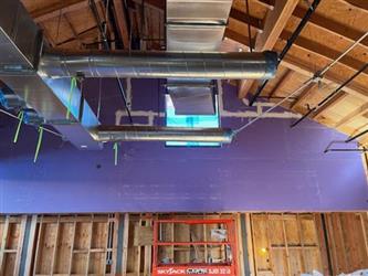 ventilation ducting hanging from the ceiling of wood framing roof