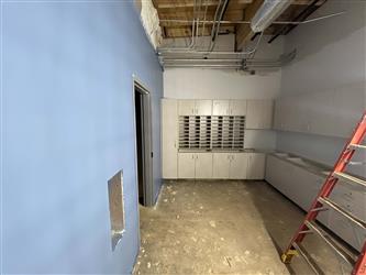 An interior staff work room with custom white cabinetry and one wall painted blue