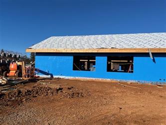 a view of the side of a building showing blue siding and window openings