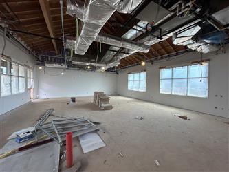 The interior of a classroom showing drywall and exposed ceiling and ventilation