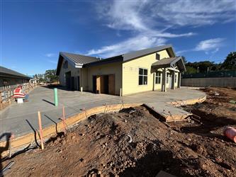 a large portion of concrete pathway with curved edges around the TK/K classroom wing