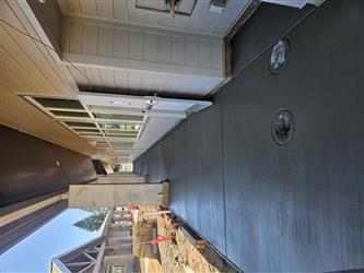 freshly poured concrete walkway alongside a classroom building with drainage ports in the foreground