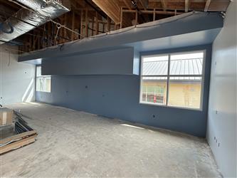 a classroom interior, painted blue and a concrete floor and windows in the wall