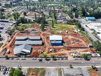 an aerial view to the South with a wide angle view of the Paradise Elementary property with the 4 new buildings and many dirt paths surrounding the buildings.