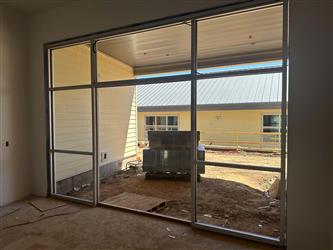 a building interior showing newly installed glass panels around a large door opening