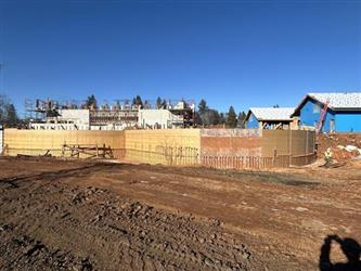 a large concrete curved retaining wall surrounded by red dirt