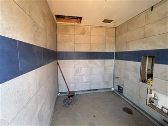 a bathroom with new tile, blue and white, installed and a concrete floor